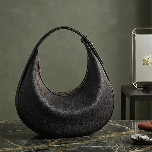 Black Pebbled Textured Half-Moon Hobo Shoulder Bag With Curved Arch Zipper Opening, Single Adjustable Integrated Shoulder Strap And Streamlined Minimalist Silhouette