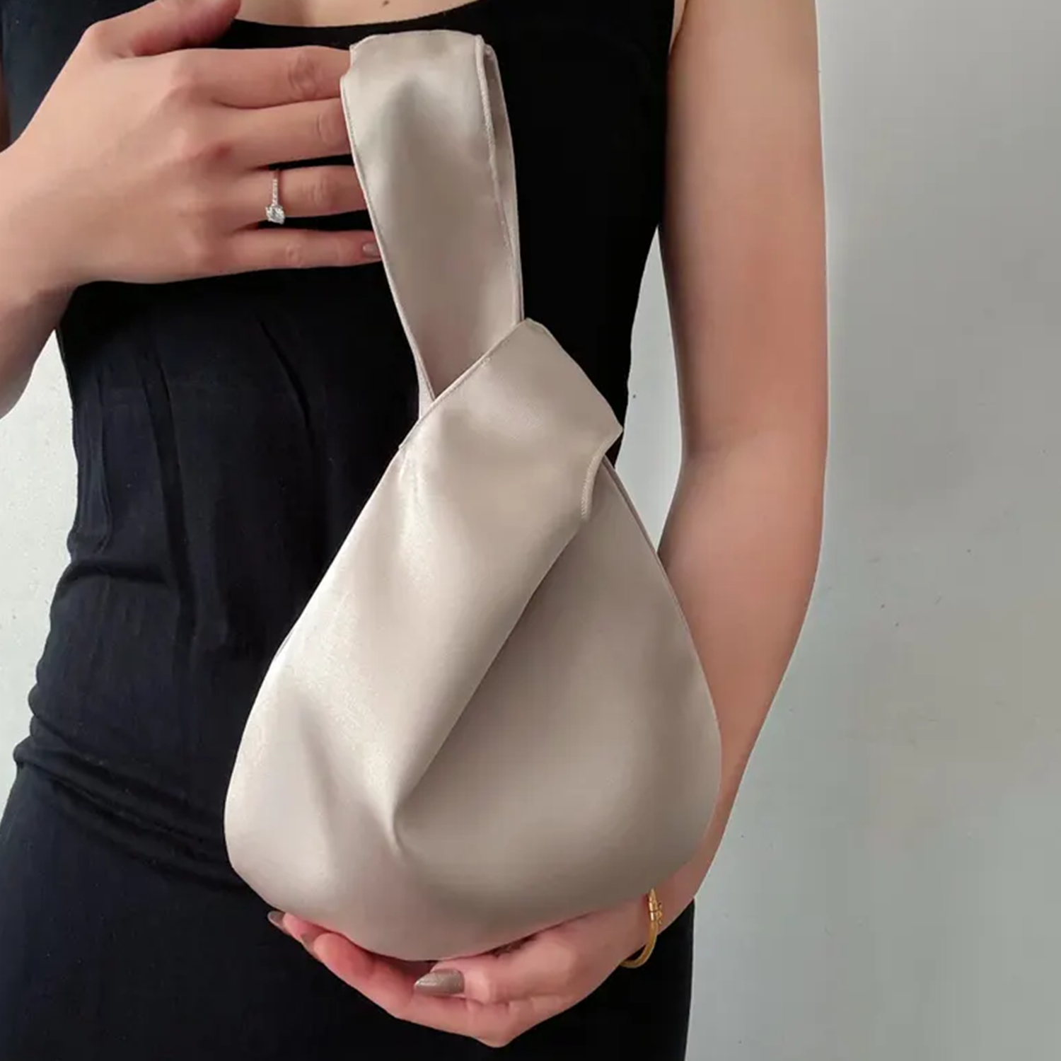 Lustrous Teardrop Knot Wrist Pouch With Interwoven Loop Strap Construction, Seamless Single Interior Cavity And Hardware-Free Minimalist Silhouette
