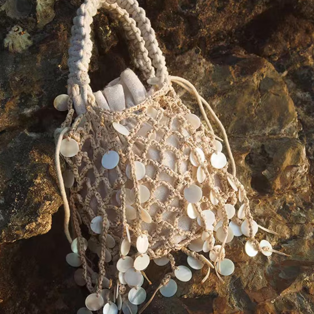 Off-White Diamond Mesh Woven Bucket Tote With Dangling Round Disc Embellishments, Braided Loop Top Handles And Drawstring Lined Interior Cavity